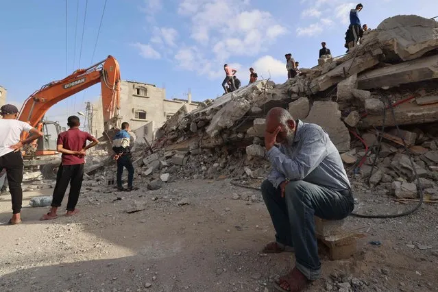 A Palestinian man wait for news of his daughter as rescue workers search for survivors under the rubble of a building hit in an overnight Israeli bombing in Rafah, in the southern Gaza Strip, on April 21, 2024 amid the ongoing conflict between Israel and the Palestinian Islamist group Hamas. (Photo by Mohammed Abed/AFP Photo)