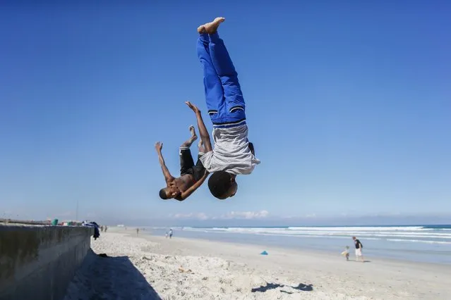 South African boys summersault off the promenade in the regenerated seaside suburb of Muizenberg, Cape Town, South Africa, 27 March 2014. Cape Town is the World Design Capital of 2014. Cape Town forms part of a broader vision to transform the city, through design, into a sustainable, productive African city, bridging historic divides and building social and economic inclusion. (Photo by Nic Bothma/EPA)