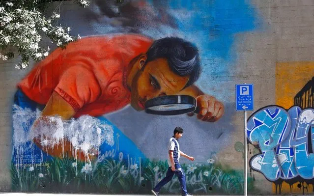 A man passes by a wall with graffiti in Beirut, Lebanon, on May 29, 2019. (Photo by Bilal Jawich/Xinhua News Agency/Alamy Live News)
