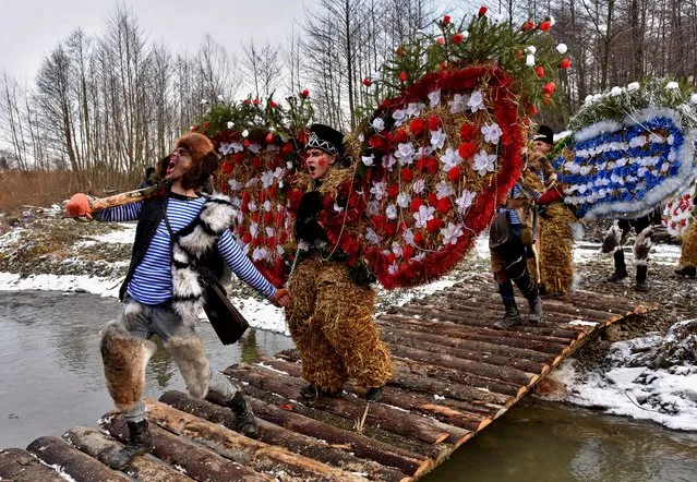 Local residents dressed in costumes perform during celebrations for Malanka traditional holiday, which is celebrated on the day of St. Basil and St. Melania, in the settlement of Krasnoilsk in Chernivtsi Region, Ukraine January 14, 2021. During the celebrations youngsters and adults wear traditional, carnival costumes, masks and visit local houses while singing carols, playing pranks or performing short plays. (Photo by Pavlo Palamarchuk/Reuters)