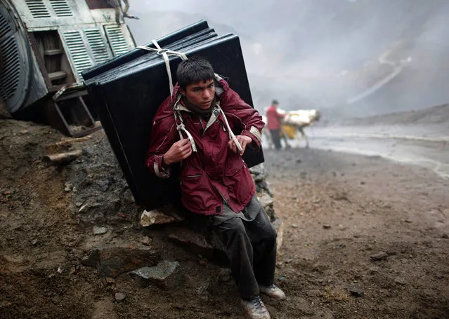 An Afghan boy carries election material on his back to polling stations which are not accessible by road in Shutul, Panjshir province, April 4, 2014. (Photo by Ahmad Masood/Reuters)