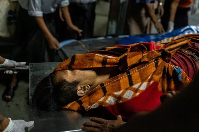 Medics wrap the body of a protester who was killed in clashes with cloth on March 03, 2021 in Yangon, Myanmar. Medics and health workers have found themselves on the front lines and under intense pressure, as they try to help anti-coup protesters as resistance continues to erupt across the country, to be met with deadly force by the military junta. The military government has intensified a crackdown on protesters in recent days, using tear gas and live ammunition, charging at and arresting protesters and journalists. At least 25 people have been killed so far, according to monitoring organizations, leaving ill-equipped medics to help scores of the injured. (Photo by Stringer/Getty Images)