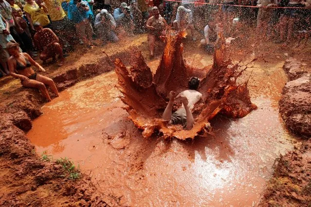 A red-clay spray showers spectators at the mud-pit belly flop, highlight of the annual Summer Redneck Games. (Photo by Sol Neelman)