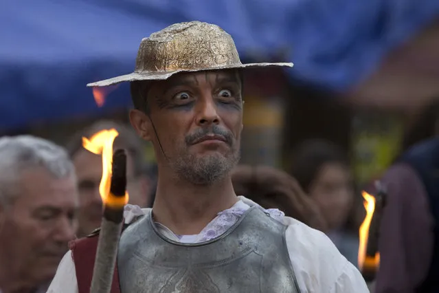 A man dressed as the character of Don Quixote holds a flaming stick during a mock funeral for Spanish writer Miguel de Cervantes, author of “Don Quixote” to commemorate the 400th anniversary of his death, in his birthplace of Alcala de Henares, Spain, Friday April 22, 2016. (Photo by Paul White/AP Photo)