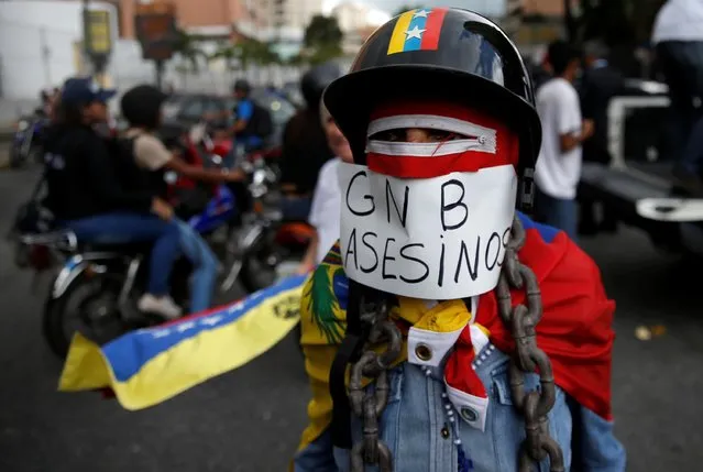A supporter of Opposition leader Juan Guaido, who many nations have recognized as the country's rightful interim ruler, is dressed-up with an attached sign at a rally against the government of President Nicolas Maduro and to commemorate the 208th anniversary of the country's independence in Caracas, Venezuela on July 5, 2019. The sign reads: “GNB (Bolivian National Guard) killers”. (Photo by Manaure Quintero/Reuters)
