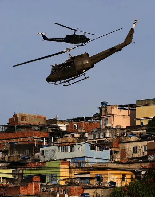 Police helicopters fly over the Mare slums complex in Rio de Janeiro March 30, 2014.The federal troops and police occupied the Mare slums complex on Sunday to help quell a surge in violent crime following attacks by drug traffickers on police posts in three slums on the north side of the city, government officials said. (Photo by Ricardo Moraes/Reuters)