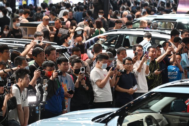 Crowds gather to view cars on the Kia stand at the Beijing Auto Show in Beijing on May 3, 2024. (Photo by Greg Baker/AFP Photo)