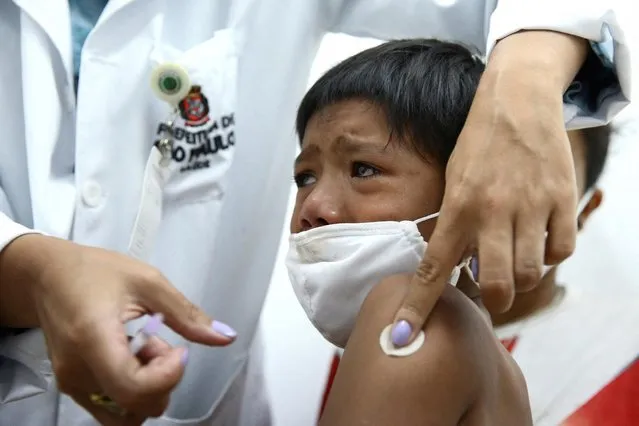 Indigenous child Stevon Tataendy, 8, reacts after receiving a dose of the Pfizer-BioNTech coronavirus disease (COVID-19) paediatric vaccine in Sao Paulo, Brazil, January 17, 2022. (Photo by Carla Carniel/Reuters)