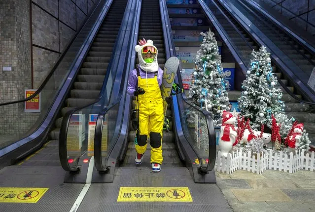 A snowboarder gets off an escalator at the Genting Snow Park, which will host events during the Beijing 2022 Winter Olympics, during a media tour on December 21, 2021 in Chongli, Zhangjiakou, in Hebei province, northern China. The area will host a number of events for the Beijing 2022 Winter Olympics which are set to open on February 4th, 2022. (Photo by Kevin Frayer/Getty Images)