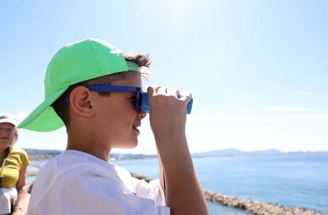 A child uses binoculars as the “Belem”, a three-masted sailing ship that carries the Olympic Flame sails to the Old Port in Marseille, France on May 8, 2024 ahead of the Paris Olympics 2024. (Photo by Manon Cruz/Reuters)