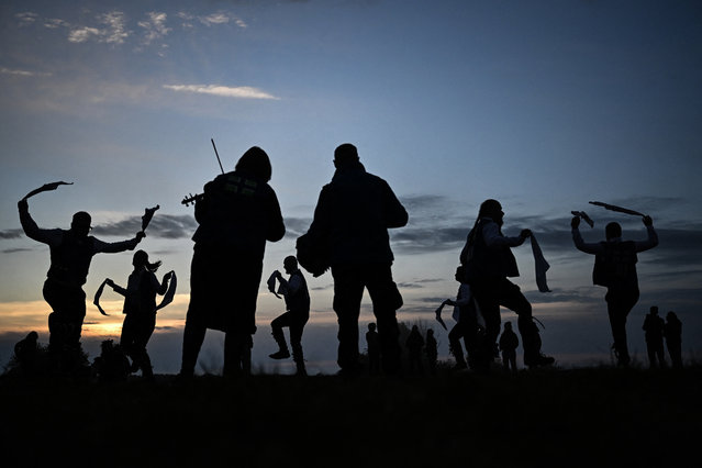Miserden Morris dancing group perform at sunrise on Rodborough Common, in Stroud, western England, as part of the May Day celebrations, on May 1, 2024. Historically, in rural Britain, May Day celebrations were associated with the fertility of spring and the start of summer. (Photo by Ben Stansall/AFP Photo)