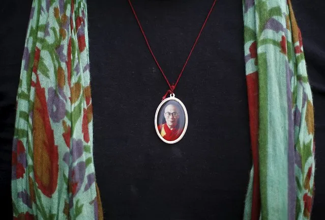 A Tibetan exile wears a locket bearing the image of their spiritual leader, the Dalai Lama, during celebrations marking his 80th birthday at Majnu Ka Tila, a Tibetan refugee camp in New Delhi, India, July 6, 2015. (Photo by Adnan Abidi/Reuters)