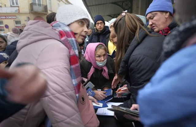 People, fleeing Ukraine, register for a bus which will take them to Germany, at the train station in Przemysl, Poland, Thursday, March 3, 2022. (Photo by Markus Schreiber/AP Photo)