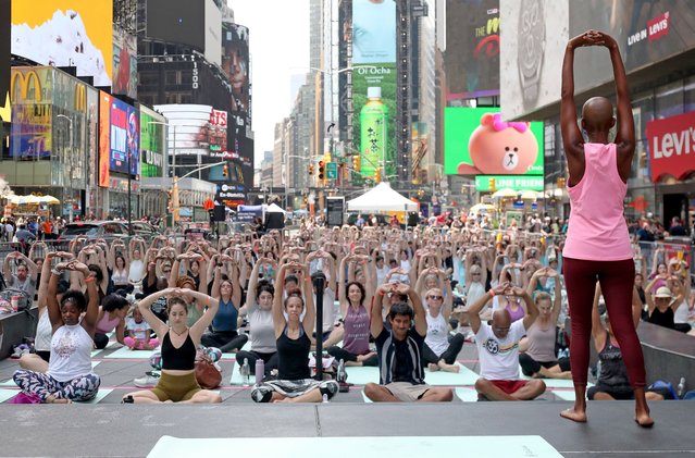 Yoga practitioners participate in yoga classes inside Times Square on the day of the summer solstice in New York City on June 20, 2024. The annual all-day outdoor yoga event, which is in its 22nd year, features classes from sun up to sun down in one of the busiest intersections of the world. (Photo by Andrew Schwartz/Splash News and Pictures)