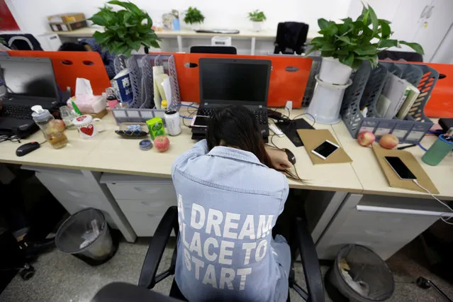 Yang Juan, an employee at Goopal Group, takes a nap in her seat after lunch, in Beijing, China, April 21, 2016. (Photo by Jason Lee/Reuters)