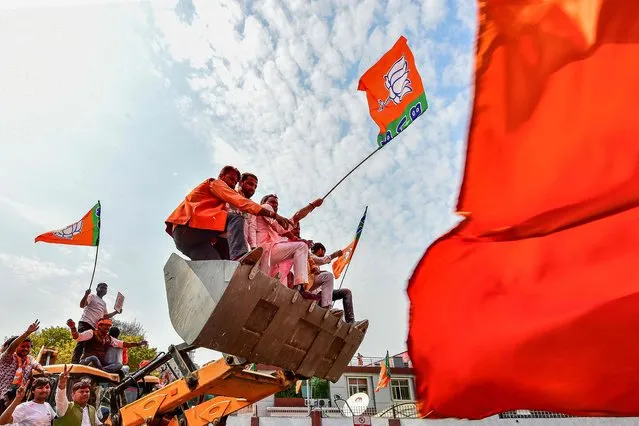 Supporters of India's Bharatiya Janata Party (BJP) celebrate outside the party office in Lucknow on March 10, 2022, on the day of counting of votes for the Uttar Padesh state asembly elections. (Photo by Sanjay Kanojia/AFP Photo)