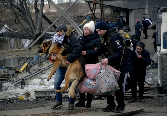 A man carries a dog as people flee, amid Russia's invasion of Ukraine, in Irpin, Ukraine, March 9, 2022. (Photo by Maksim Levin/Reuters)