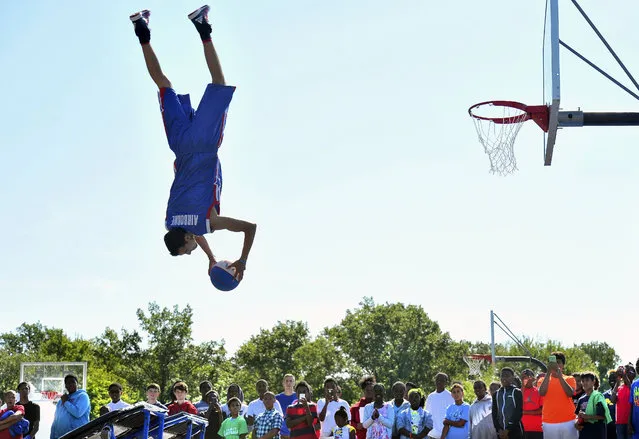 “Airborne” of the Detroit Pistons Flight Crew goes heels over head during a high flying basketball dunking show for the amazed fans at the 33rd Annual Metro Detroit Youth Day on Belle Isle in Detroit, Wednesday, July 15, 2015. (Photo by Daniel Mears/Detroit News via AP Photo)