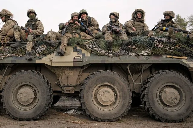 Ukrainian servicemen ride on an armored transporter driving through a Russian position overran by Ukrainian forces outside Kyiv, Ukraine, Thursday, March 31, 2022. (Photo by Vadim Ghirda/AP Photo)
