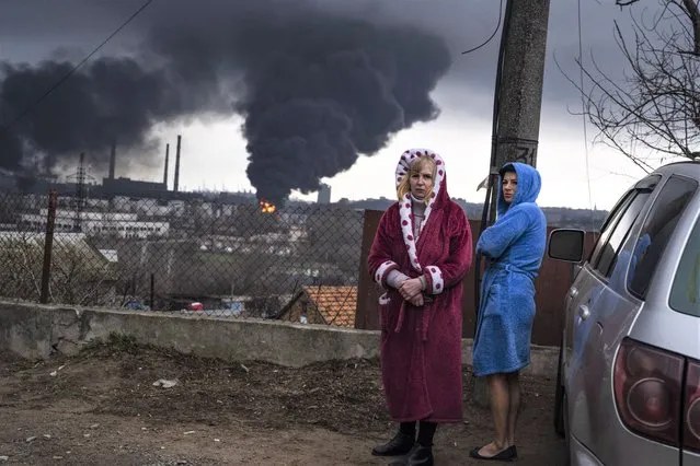 Women stay next to a car as smoke rises in the air in the background after shelling in Odesa, Ukraine, Sunday, April 3, 2022. (Photo by Petros Giannakouris/AP Photo)