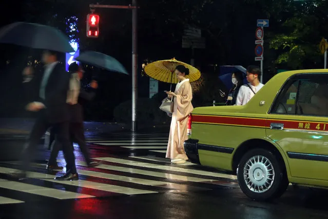 A taxi cab passes a woman wearing a kimono at a street crossing in Tokyo, Japan on October 17, 2019. Japan is hosting the Rugby World Cup and will also host the Olympic Games in 2020. (Photo by Kevin Coombs/Reuters)