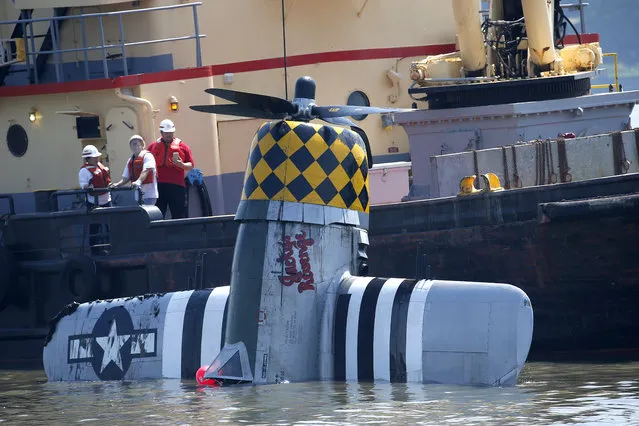 Officials remove a plane out of the Hudson River a day after it crashed, Saturday, May 28, 2016, in North Bergen, N.J. The World War II vintage P-47 Thunderbolt aircraft crashed into the river Friday, May 27, killing its pilot. (Photo by Julio Cortez/AP Photo)