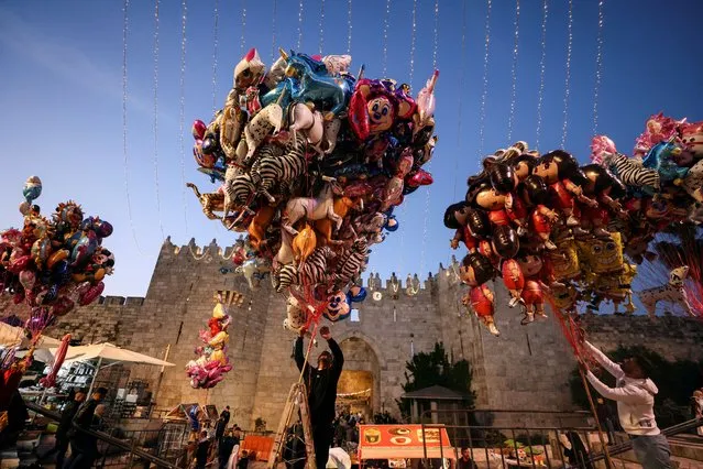 Vendors set balloons for sale as Palestinians celebrate Eid al-Fitr at Damascus Gate to Jerusalem's Old City on May 2, 2022. (Photo by Ammar Awad/Reuters)