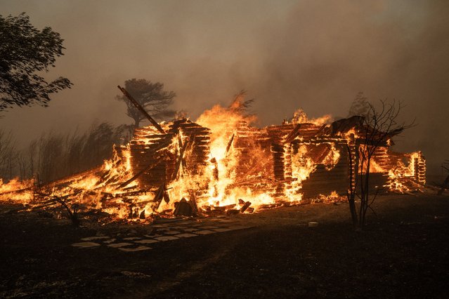 A house burns during a wildfire in Varnavas, north of Athens, on August 11, 2024. - Greece was battling several wildfires on August 11, with smoke covering parts of the capital Athens in a haze, amid warnings for extreme weather conditions for the rest of the week. (Photo by Angelos Tzortzinis/AFP Photo)