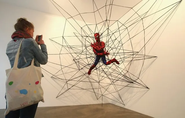 The knitted sculpture 'Spiderman' by Patricia Waller, featuring the comic book character as an imprisoned victim of his own web, hangs in the 'Broken Heroes' exhibition at the Deschler Gallery