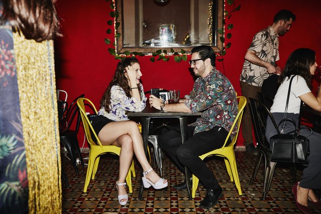 Smiling couple in discussion while seated at table in night club. (Photo by Thomas Barwick/Getty Images)