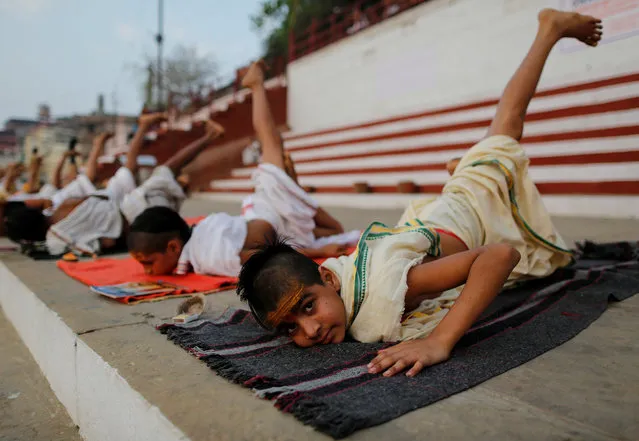 Students from a Hindu religious school practice yoga on the banks of the river Ganges in Varanasi, India, April 7, 2017. (Photo by Danish Siddiqui/Reuters)