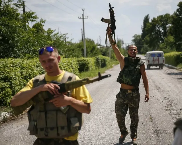 Ukrainian soldiers stand guard in the eastern Ukrainian town of Seversk July 12, 2014. Ukrainian war planes bombarded separatists along a broad front on Saturday, inflicting huge losses, Kiev said, after President Petro Poroshenko said “scores and hundreds” would be made to pay for a deadly missile attack on Ukrainian forces. (Photo by Gleb Garanich/Reuters)