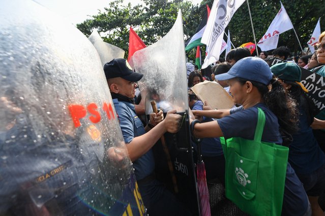 Policemen (L) scuffle with protesters during a pro-Palestinian rally held near the US embassy in Manila on October 5, 2024 to mark one year since the start of the Gaza war. Hamas's attack on October 7 resulted in the deaths of 1,205 people on the Israeli side, most of them civilians, according to an AFP tally based on Israeli official figures. Israel's retaliatory military campaign in Gaza has killed at least 41,431 Palestinians, the majority of them civilians, according to figures provided by the health ministry in Hamas-run Gaza. The United Nations has acknowledged the toll as reliable. (Photo by Ted Aljibe/AFP Photo)