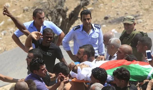 Mourners carry the body of Palestinian Rafiq Kamel Rafiq, 21, during his funeral in the West Bank town of Tubas near Jenin August 16, 2015. Rafiq was shot dead on Saturday after stabbing an Israeli paramilitary policeman patrolling a road in the occupied West Bank, police said. (Photo by Abed Omar Qusini/Reuters)