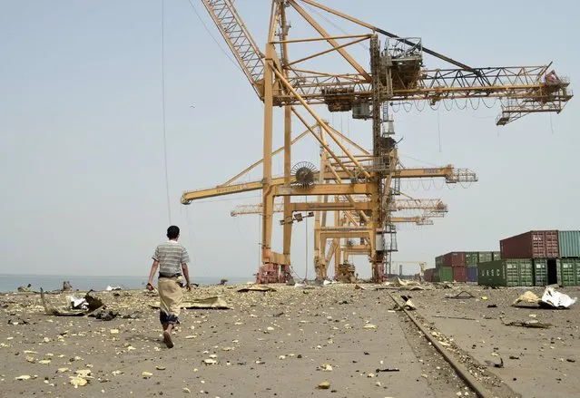 A worker walk on debris following an air strike on Yemen's Hodeida port August 18, 2015. Warplanes from a Saudi-led coalition hit the Houthi-controlled Red Sea port of Hodeida on Tuesday, destroying cranes and warehouses in the main entry point for aid supplies to Yemen's north. (Photo by Reuters/Stringer)