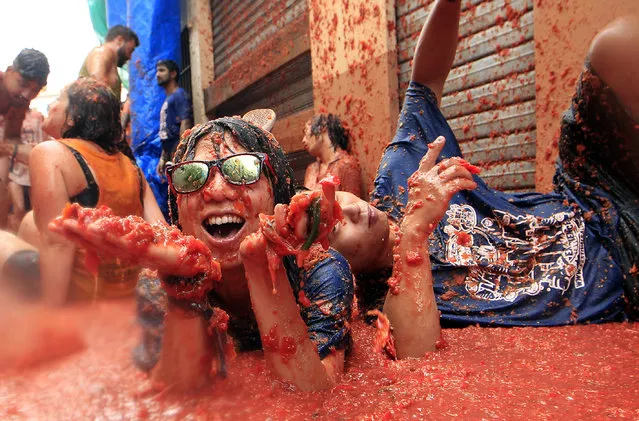 Revelers enjoy as they throw tomatoes at each other, during the annual “Tomatina”, tomato fight fiesta, in the village of Bunol, 50 kilometers outside Valencia, Spain, Wednesday, August 30, 2017. (Photo by Alberto Saiz/AP Photo)