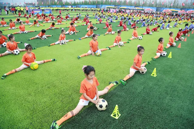 Students perform with soccer balls during an opening ceremony of a soccer event, in Dalian, Liaoning province, China, July 16, 2016. (Photo by Reuters/Stringer)