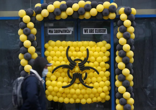 A pedestrian wearing a protective mask walks past a warning sign made of balloons outside a closed cafe, after the city authorities announced a partial lockdown ordering residents to stay at home to prevent the spread of coronavirus disease (COVID-19), in Moscow, Russia on March 30, 2020. (Photo by Maxim Shemetov/Reuters)