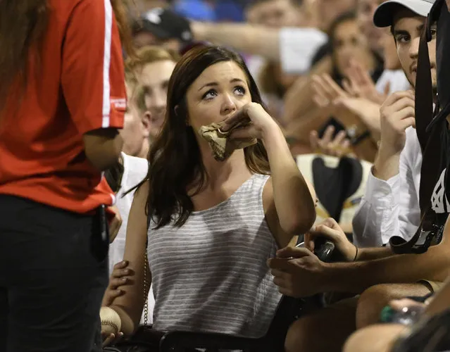A fan wipes her lip after she was hit on the mouth by a foul ball hit by Kansas City Royals' Brandon Moss during the third inning of the Royals' baseball game against the Chicago White Sox, Friday, September 22, 2017, in Chicago. (Photo by David Banks/AP Photo)