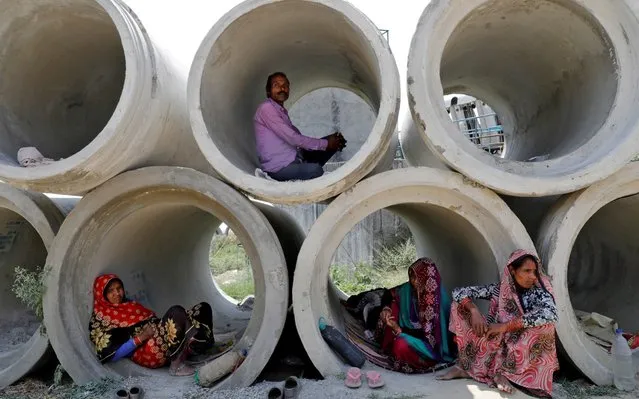 Migrant labourers rest in cement pipes during an extended nationwide lockdown to slow the spreading of coronavirus disease (COVID-19) in Lucknow, India, April 22, 2020. (Photo by Pawan Kumar/Reuters)