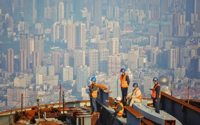  Employees wear face masks as they work at the construction site of the Wuhan Greenland Center, a 636-meter high skyscraper, in Wuhan in China's central Hubei province on April 24, 2020. (Photo by AFP Photo/China Stringer Network)