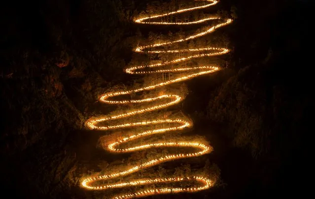 People holding torches walk on a mountain trail during a trekking event to mark the 70th anniversary of the end of World War Two, in Qinglong county, Guizhou province, September 4, 2015. Around 2974 people participated in trekking the trail, through where the American aid to China were transported from Myanmar to China's frontlines during the World War Two, according to local media. (Photo by Reuters/Stringer)