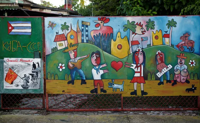 A painting of Cuban artist Jose Fuster is seen on the door of a house in the seaside village of Jaimanitas in Havana, Cuba, July 14, 2016. Fuster has also adorned the facades of houses in the neighborhood with Picasso-like paintings and playful ceramic figures, transforming the humble neighborhood into an island of brightness. (Photo by Enrique de la Osa/Reuters)
