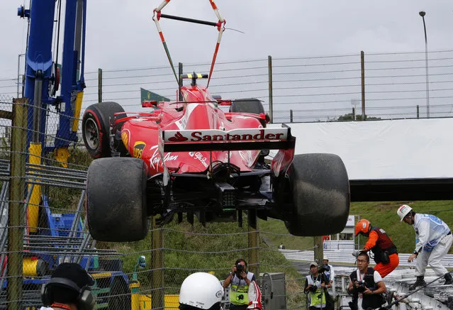 Ferrari driver Kimi Raikkonen of Finland's car is removed from the circuit after he crashed during the third practice session for the Japanese Formula One Grand Prix at Suzuka, Japan, Saturday, October 7, 2017. (Photo by Eugene Hoshiko/AP Photo)