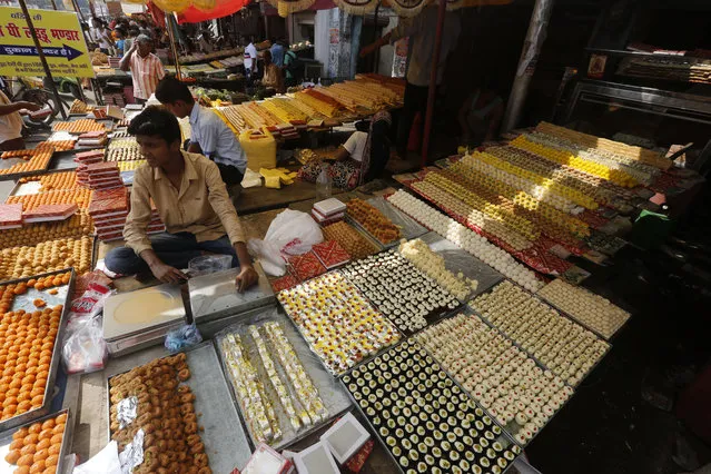 An Indian vendor displays sweets for sale on Diwali, the festival of lights, in Allahabad, India, Thursday, October 19, 2017. (Photo by Rajesh Kumar Singh/AP Photo)