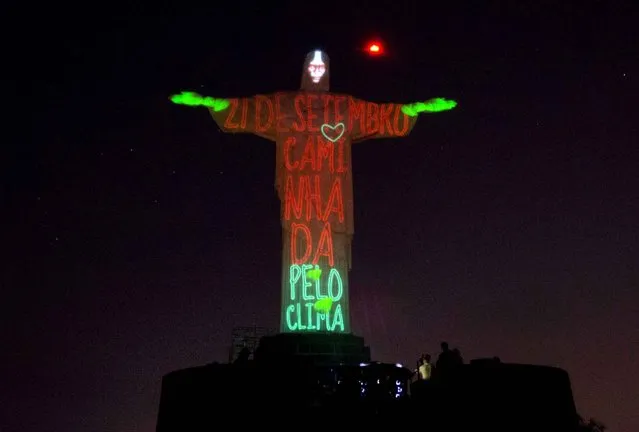 Christ the Redeemer statue is lit up with the words that read in Portuguese “21 September, March for the Climate”, in Rio de Janeiro, Brazil, Thursday, September 18, 2014. The statue was lit up in as a symbolic warning to the dangers of climate change. This event is in support of the Global People’s Climate March, scheduled for the next Sunday, which is asking for solutions to combat global climate change, in advance of the United Nations Climate Summit to be held on September 23. (Photo by Silvia Izquierdo/AP Photo)