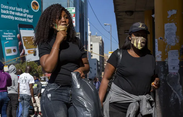 People wearing face masks to protect against coronavirus, walk on the street in downtown Johannesburg, South Africa, Monday, May 11, 2020. (Photo by Themba Hadebe/AP Photo)