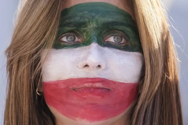 A woman with the Iran flag colors painted on her face participates in a rally as thousands demonstrate in support of Iranian women in downtown Los Angeles, California, USA, 01 October 2022. This demonstration takes place following the death of Mahsa Amini while detained by Iran's morality police and Hadis Najafi who was shot during a protest. (Photo by Ringo Chiu/EPA/EFE)