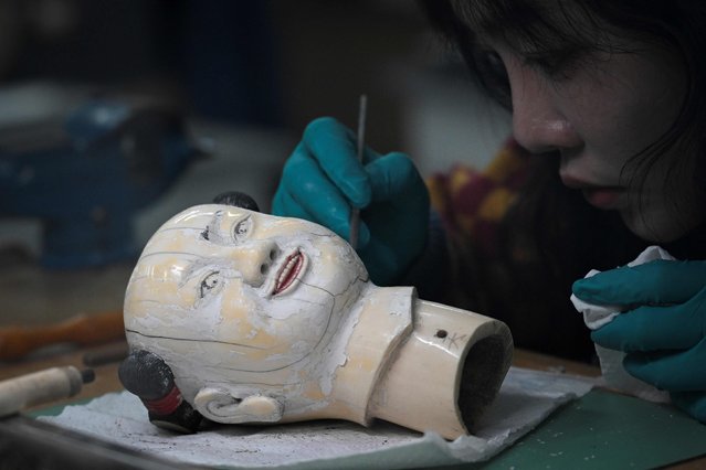 A restorer of cultural relics works at a restoration room of antique clocks at the Palace Museum during a media tour organized by the government in Beijing on February 21, 2025. (Photo by Wang Zhao/AFP Photo)
