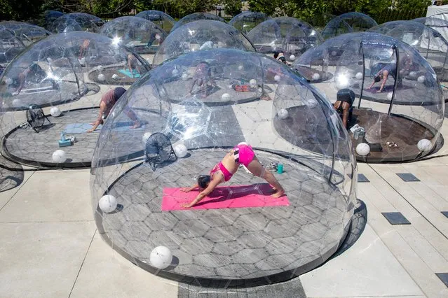 People participate in an outdoor yoga class by LMNTS Outdoor Studio, in a dome to facilitate social distancing and proper protocols to prevent the spread of coronavirus, in Toronto, Ontario, Canada on June 21, 2020. (Photo by Carlos Osorio/Reuters)
